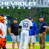 Group of 4 with Detroit Tigers player on Comerica Park field